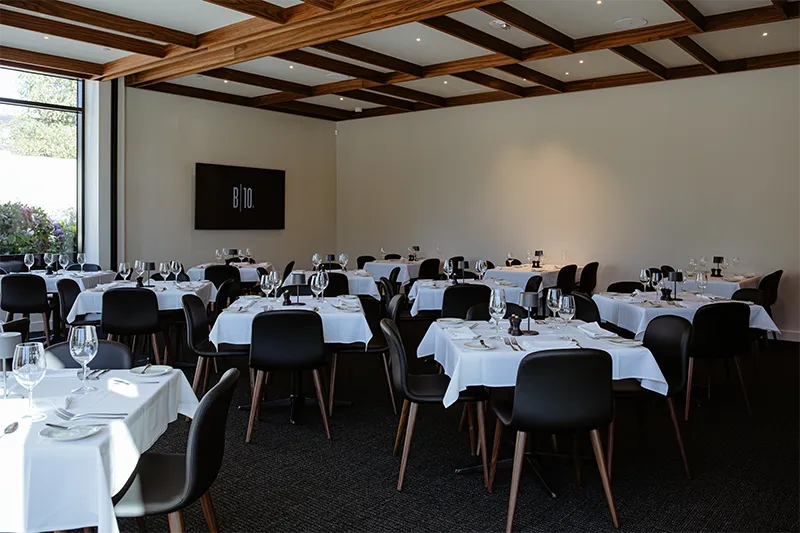 Set tables in the Continental Divide private dining room with a TV on the wall Chef's Table Gallery 4 | Broadway 10 Bar and Chophouse